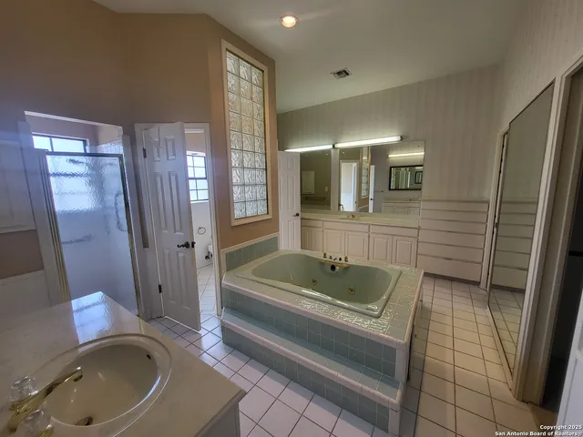 a bathroom with a tub sink and mirror