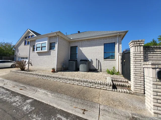 a view of a house with a small yard and large parking space