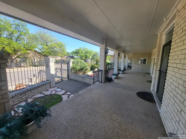 a view of a porch with furniture and floor to ceiling window