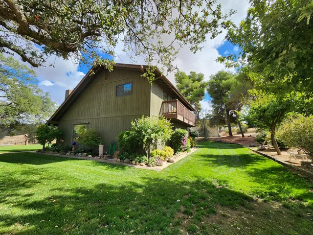 a view of a patio with table and chairs potted plants and large tree