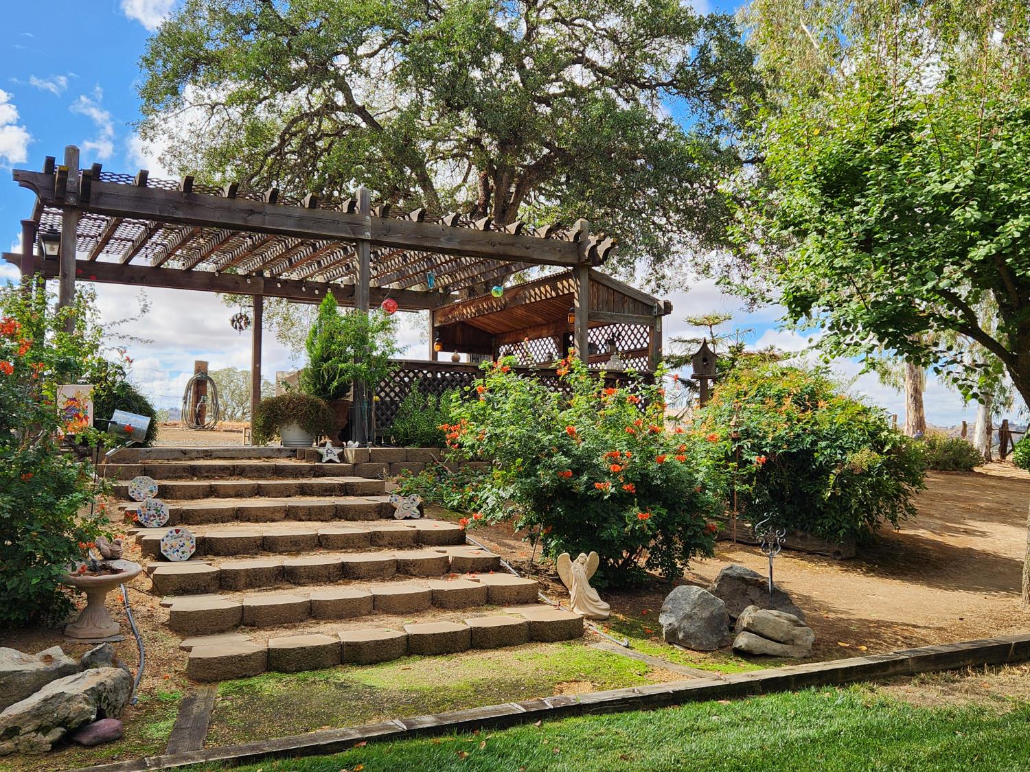 22266 Frontier Road Clovis, CA 93619 - Photo 15 of 61 a view of a patio with table and chairs potted plants and large tree