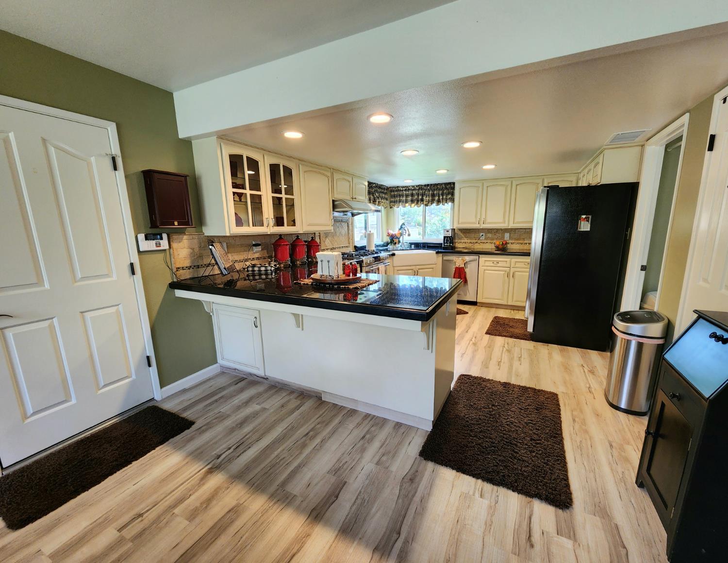 22266 Frontier Road Clovis, CA 93619 - Photo 20 of 61 a kitchen with stainless steel appliances kitchen island granite countertop a refrigerator a sink a stove and white cabinets with wooden floor