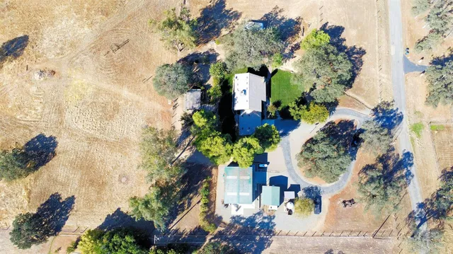 a front view of a house with a garden and trees