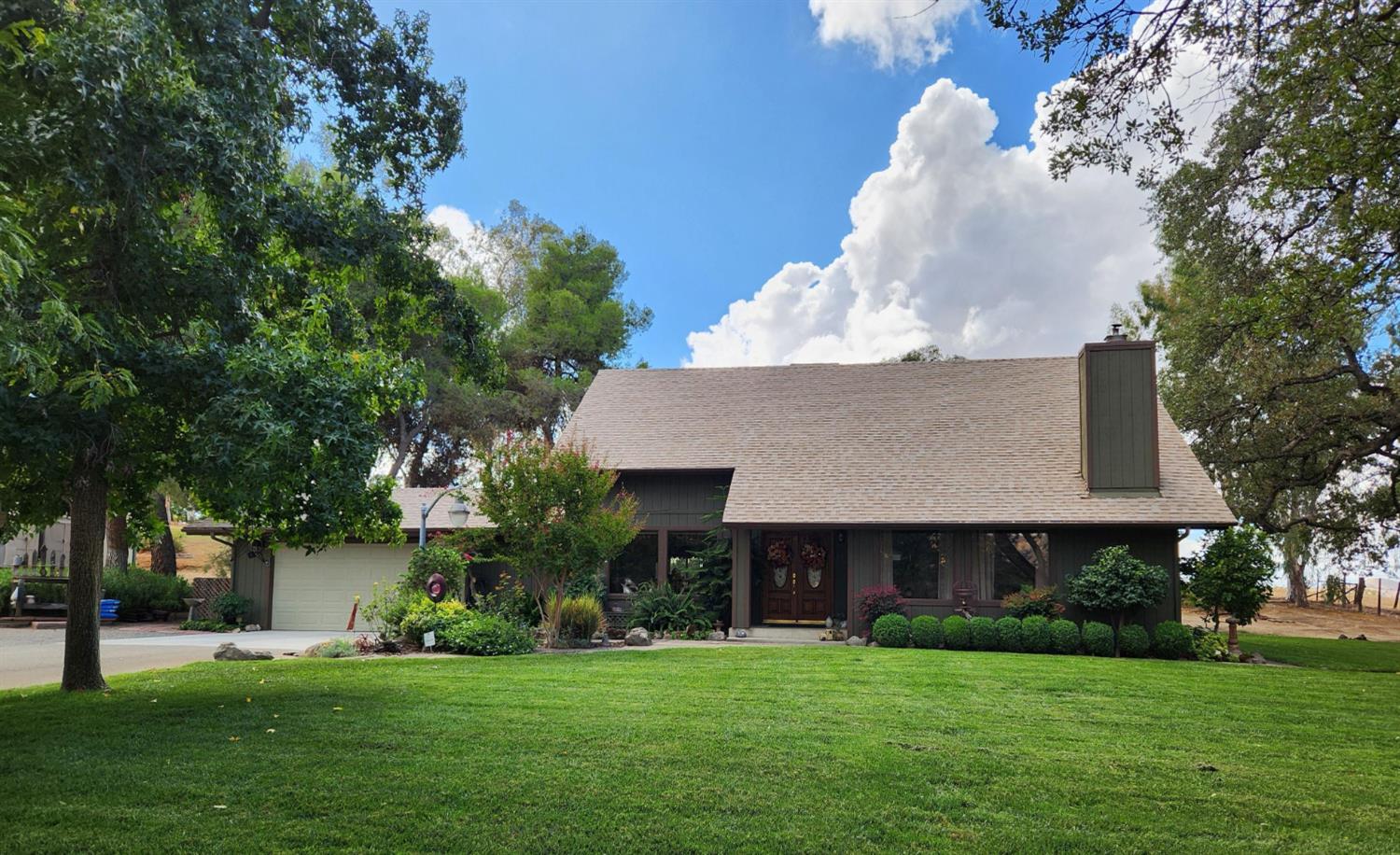 22266 Frontier Road Clovis, CA 93619 - Photo 6 of 61 a front view of a house with a garden and trees