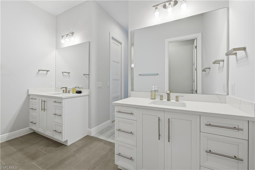 711 91st Avenue North Naples, FL 34108 - Photo 11 of 29 a bathroom with a double vanity sink and mirror