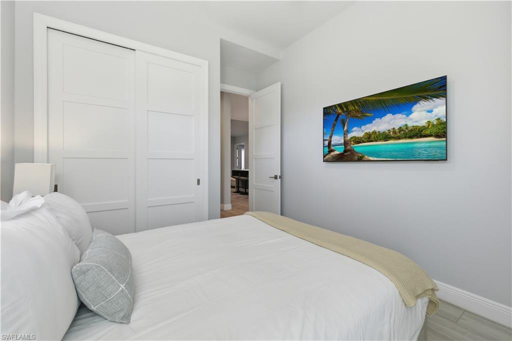 711 91st Avenue North Naples, FL 34108 - Photo 16 of 29 a bedroom with a bed and a painting on the wall
