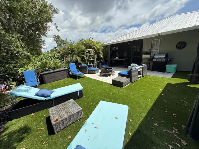 a view of a backyard with couches plants and large tree