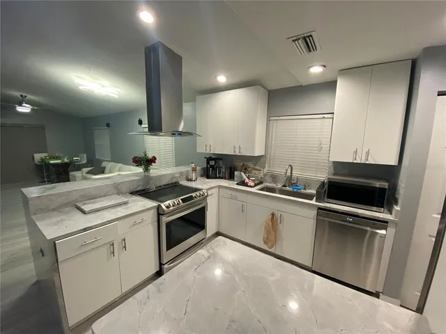a kitchen with a sink and white cabinets