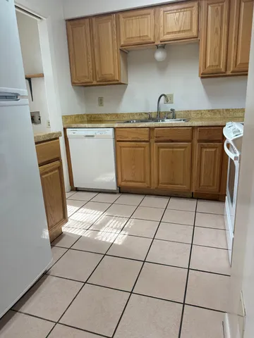 a kitchen with a sink a stove top oven and white cabinets