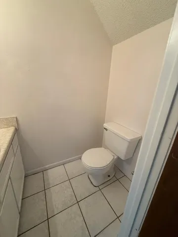 a white toilet sitting next to a white sink and vanity