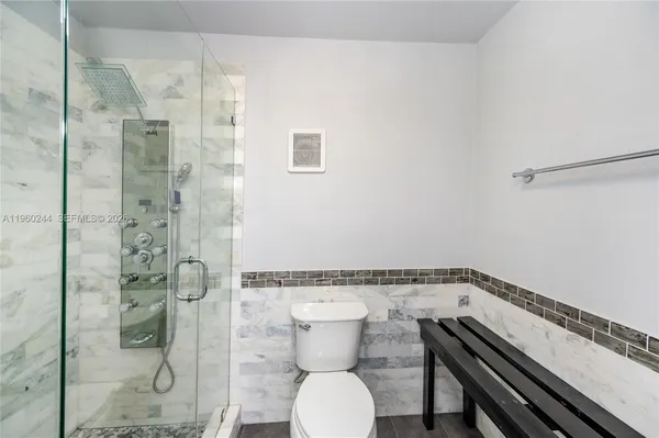 a bathroom with a granite countertop sink a toilet and shower