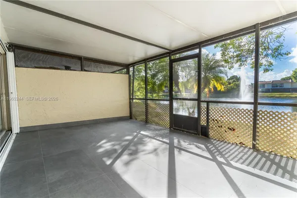 en empty room with wooden floor and windows