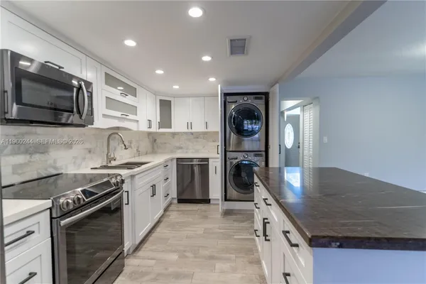 a kitchen with stainless steel appliances granite countertop a stove a sink and a microwave