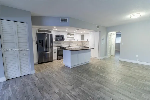 a kitchen with stainless steel appliances granite countertop a refrigerator and a sink