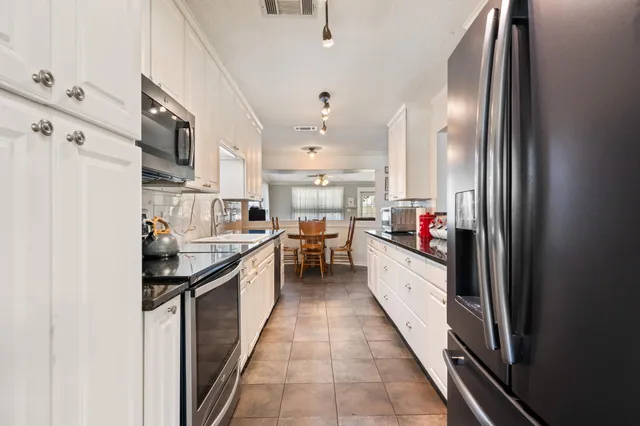 a kitchen with stainless steel appliances granite countertop a sink and cabinets