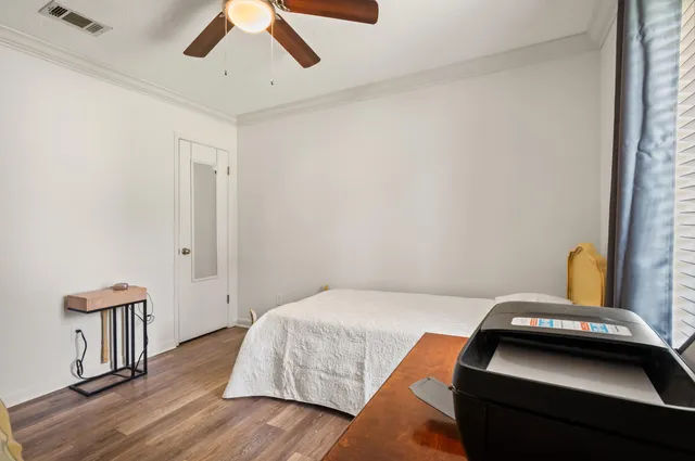 a front view of a house with a yard fountain and a tree