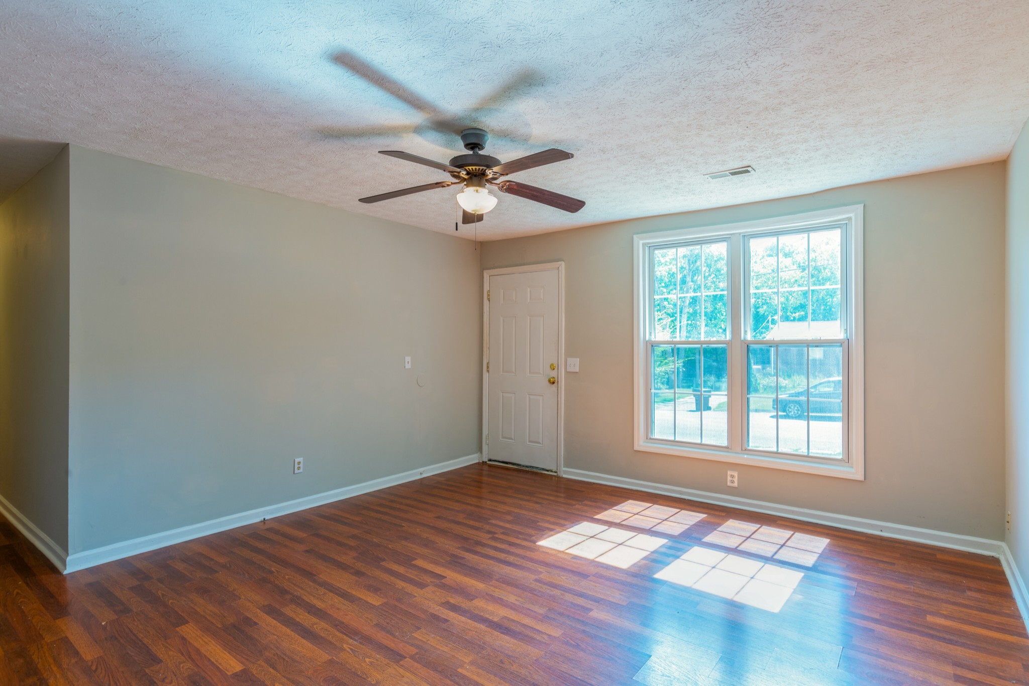 229 Manzano Road Madison, TN 37115 - Photo 7 of 26 a view of an empty room with a window and wooden floor