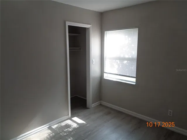 a view of a small space with wooden floor and a window