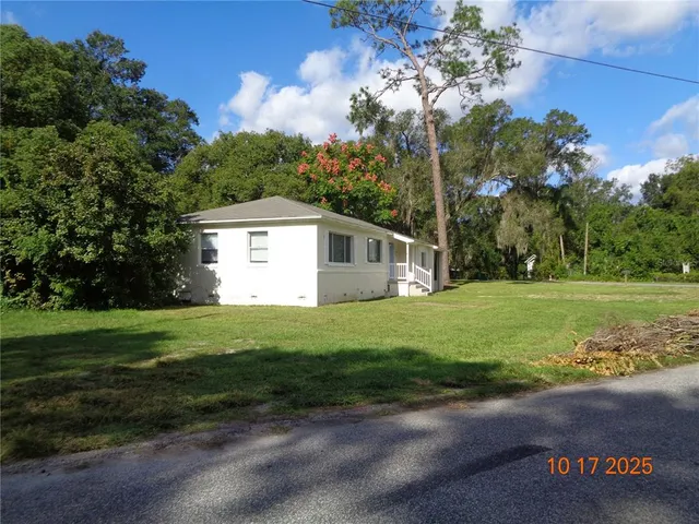 a view of a house with a yard and sitting area