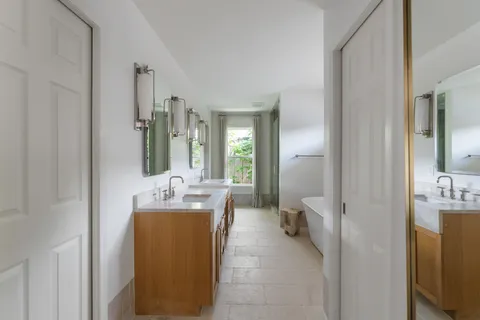 a bathroom with a tub sink and mirror