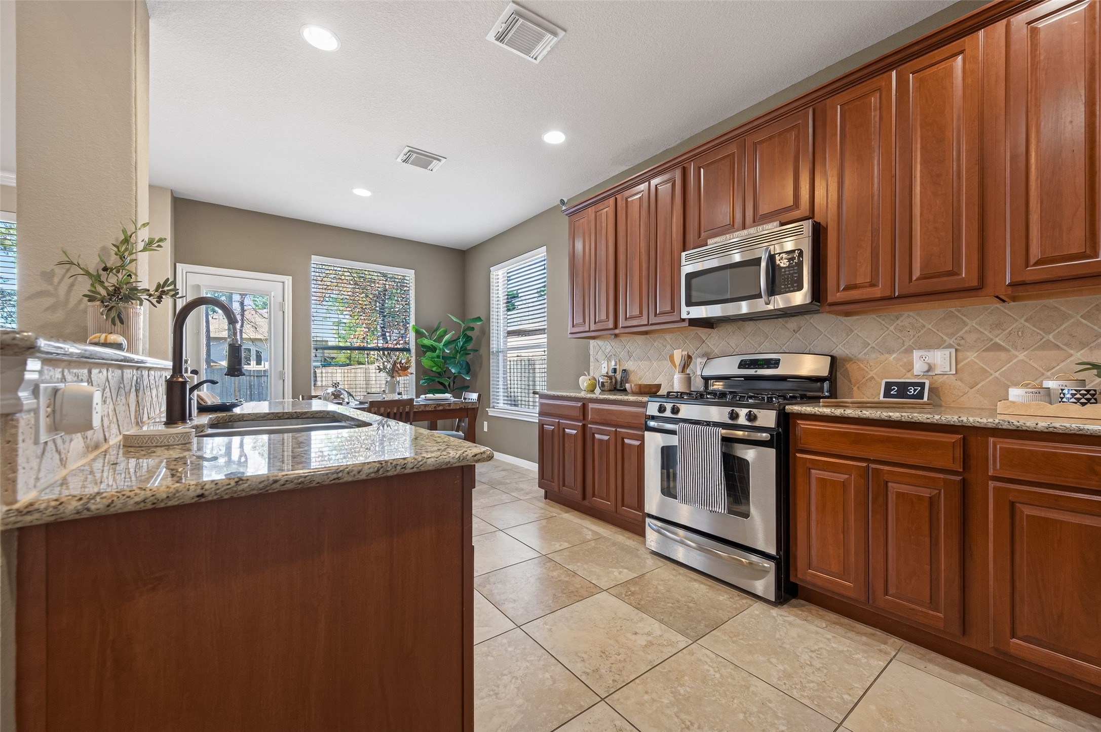 155 Rocky Point Drive Spring, TX 77389 - Photo 7 of 28 a kitchen with stainless steel appliances granite countertop a stove sink microwave and cabinets