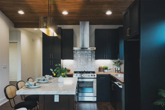 a kitchen with stainless steel appliances granite countertop a stove and a refrigerator