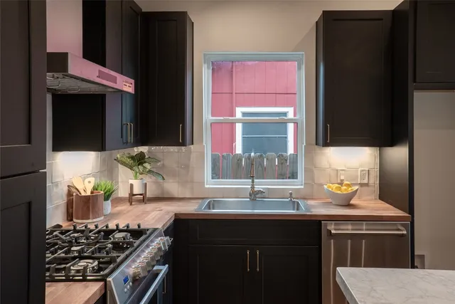 a kitchen with a sink stove top oven and cabinets