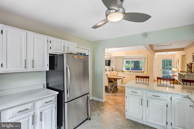 a kitchen with stainless steel appliances granite countertop a refrigerator a stove a sink and white cabinets