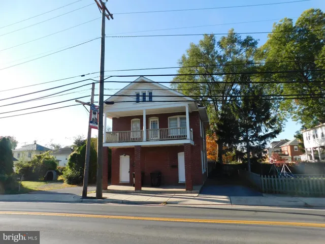 a view of a hallway with wooden floor and windows