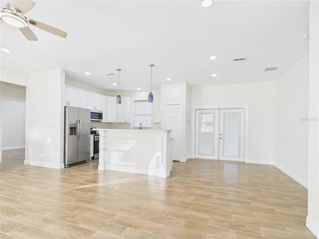 a view of a kitchen with kitchen island a sink stainless steel appliances and cabinets