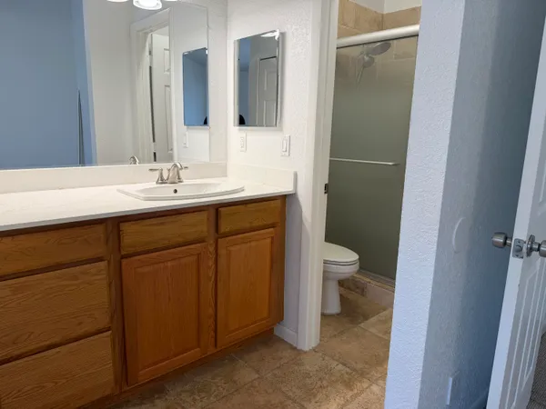 a bathroom with a toilet a sink a mirror and a shower