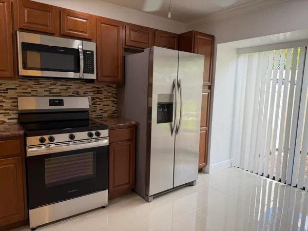 a kitchen with granite countertop cabinets stainless steel appliances and a window