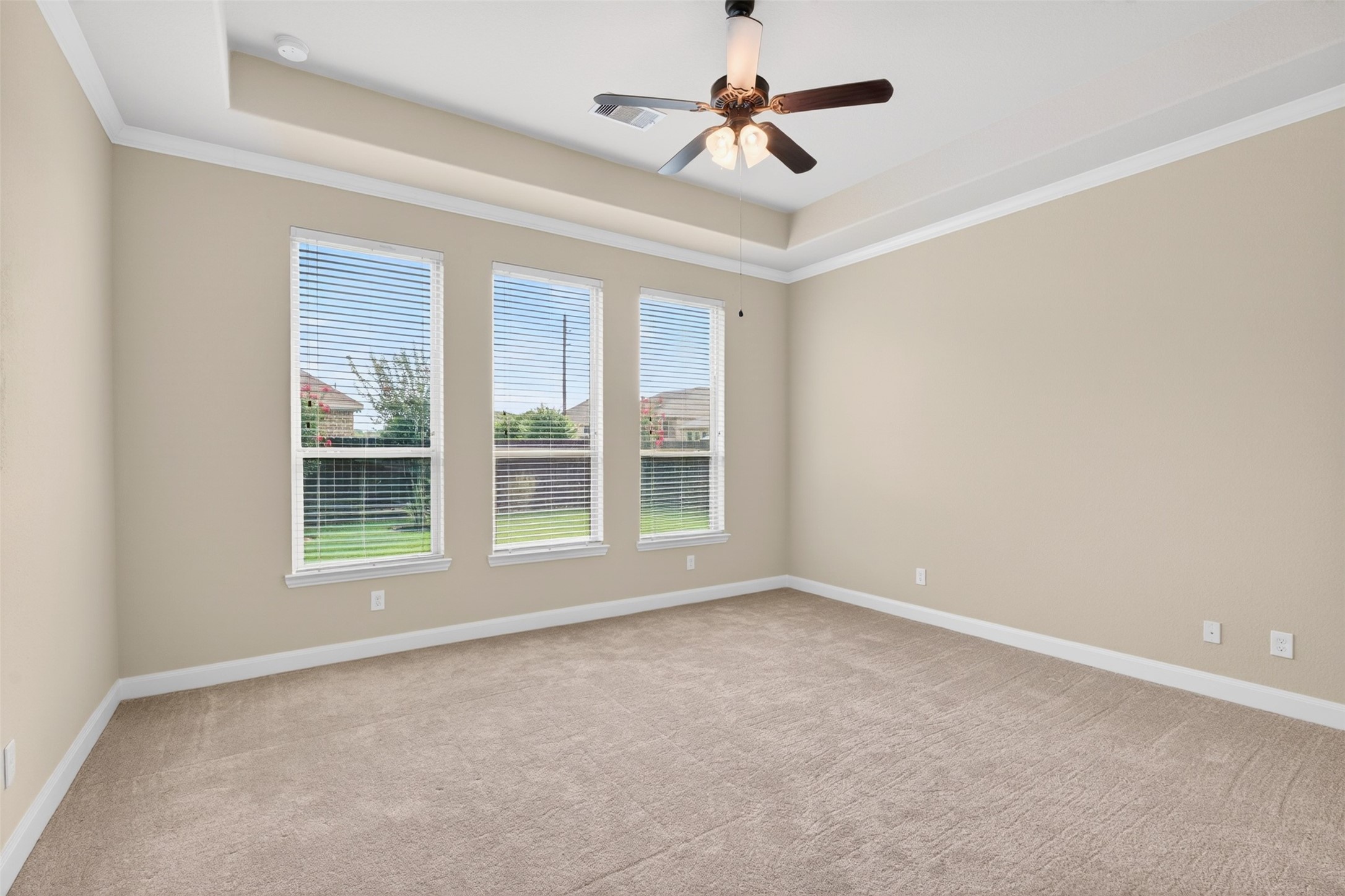18202 Wedgewood Bluff Court Spring, TX 77379 - Photo 25 of 50 Spacious primary bedroom with tray ceiling, ceiling fan, and multiple windows.
