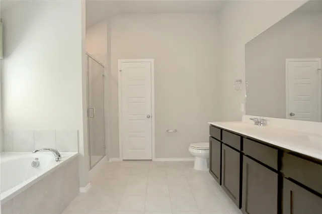 a spacious bathroom with a tub sink and mirror