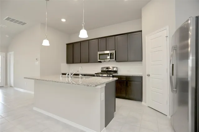 a kitchen with kitchen island a sink stainless steel appliances and cabinets