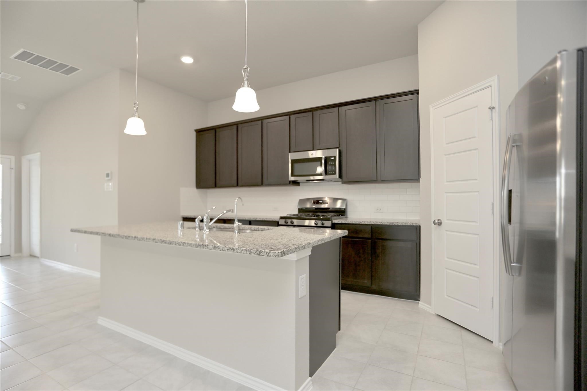 2123 Santa Ana Way Baytown, TX 77523 - Photo 3 of 20 a kitchen with kitchen island a sink stainless steel appliances and cabinets