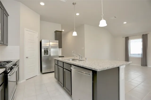 a kitchen with stainless steel appliances granite countertop a sink and a refrigerator