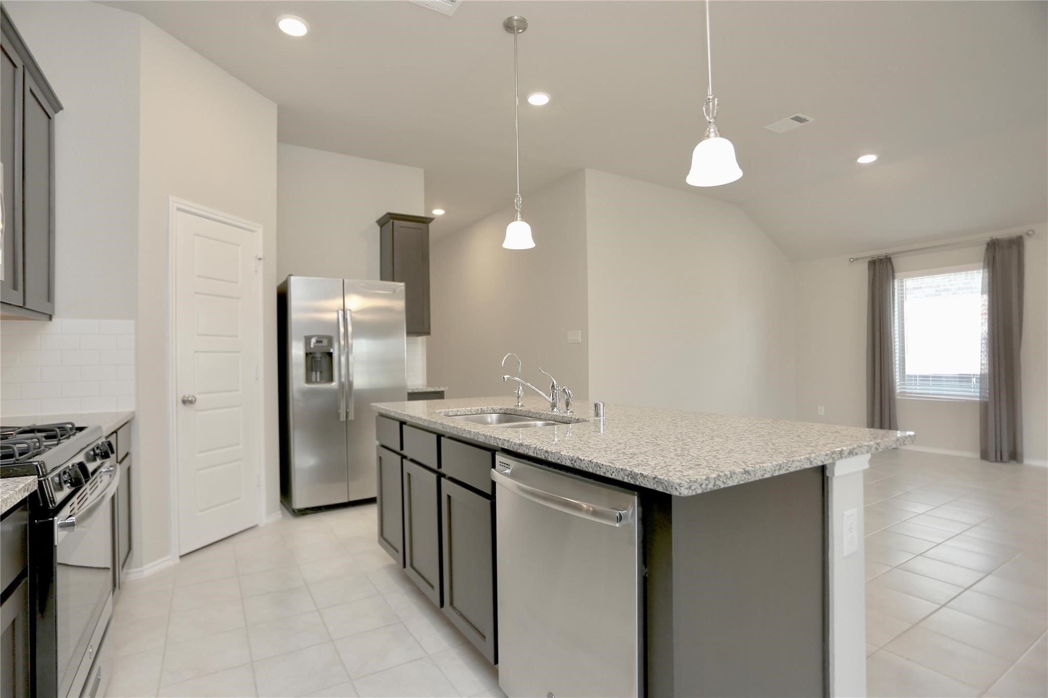 2123 Santa Ana Way Baytown, TX 77523 - Photo 5 of 20 a kitchen with stainless steel appliances granite countertop a sink and a refrigerator