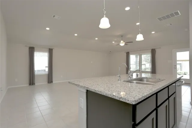 a kitchen with granite countertop kitchen island a sink appliances and a counter space