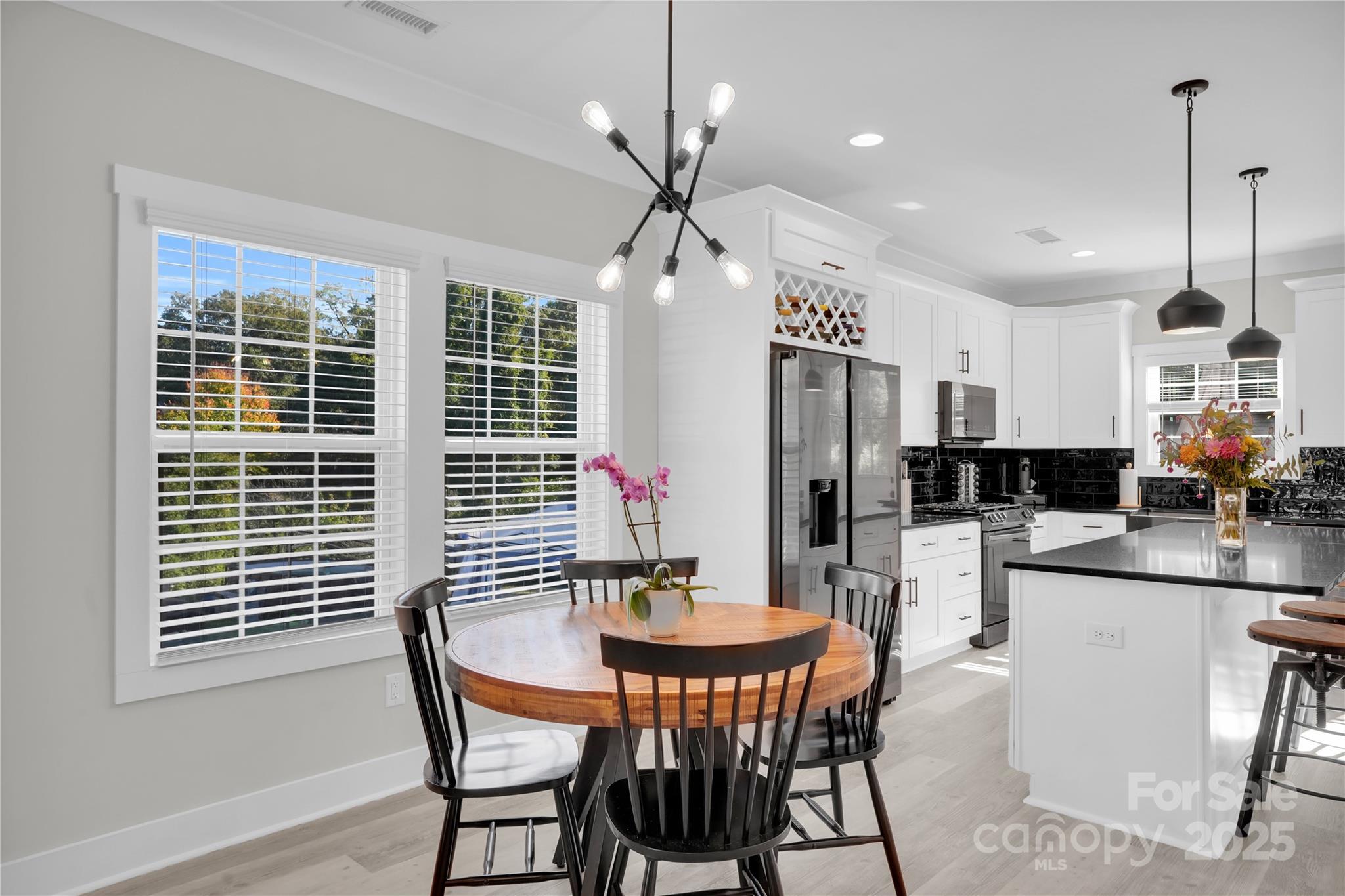 203 A Todd Street Belmont, NC 28012 - Photo 7 of 30 a kitchen with stainless steel appliances kitchen island granite countertop a dining table chairs and white cabinets