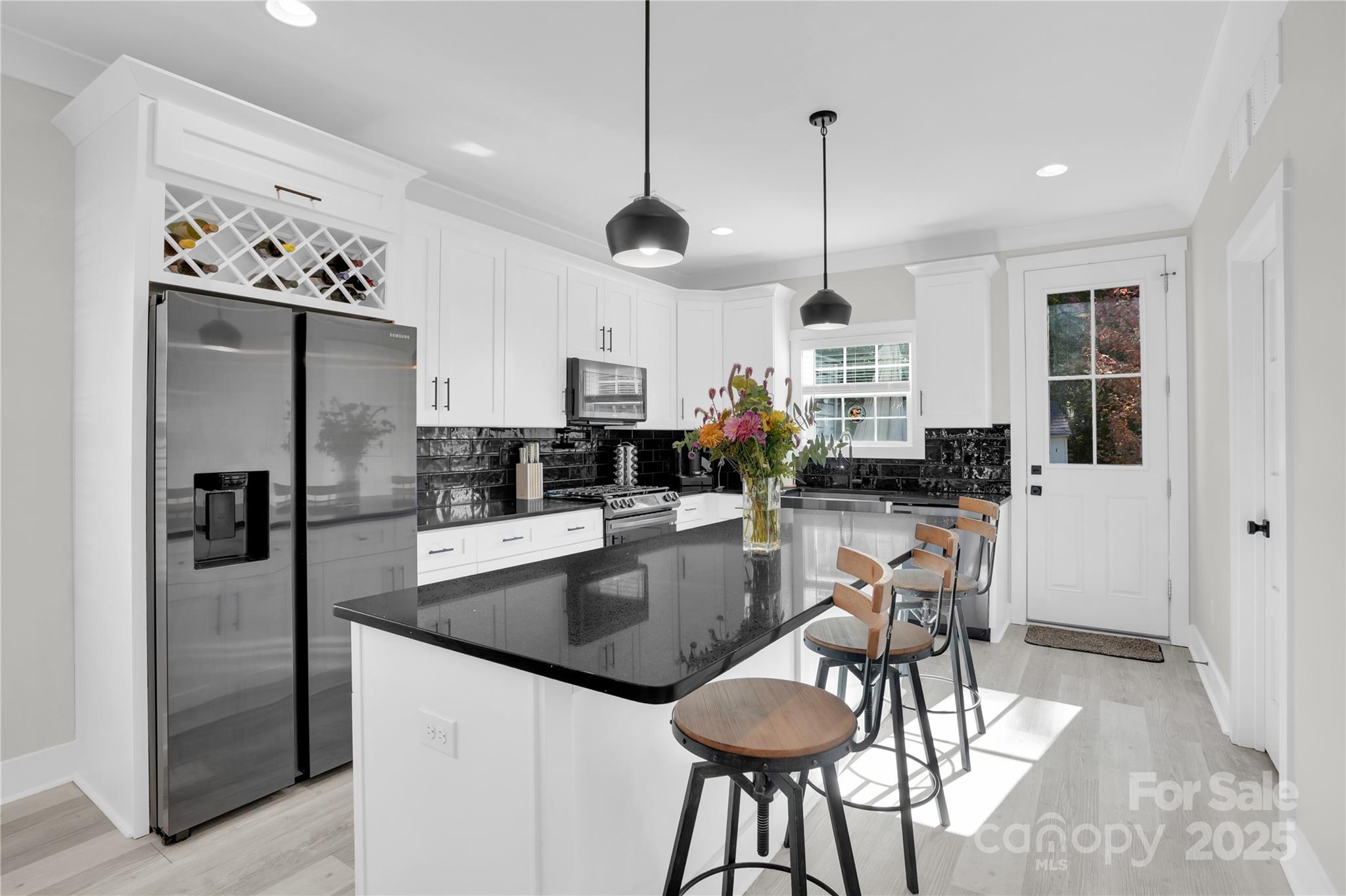 203 A Todd Street Belmont, NC 28012 - Photo 9 of 30 a kitchen with stainless steel appliances granite countertop a refrigerator a sink dishwasher a dining table and chairs with wooden floor
