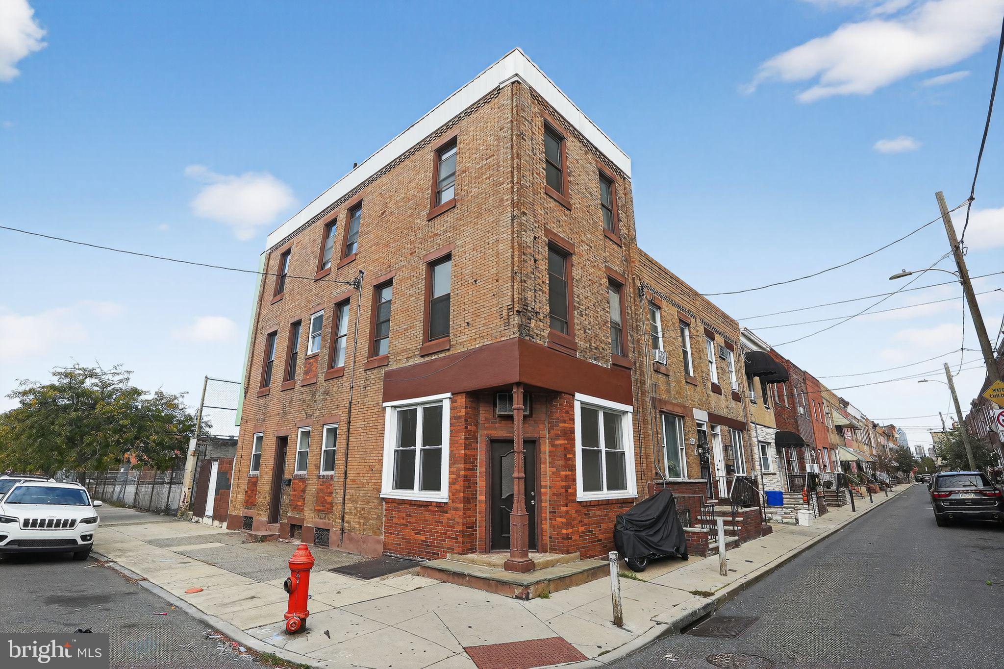 2252 South Hicks Street, Unit 3 Philadelphia, PA 19145 - Photo 2 of 6 a front view of a building with lot of cars and trees