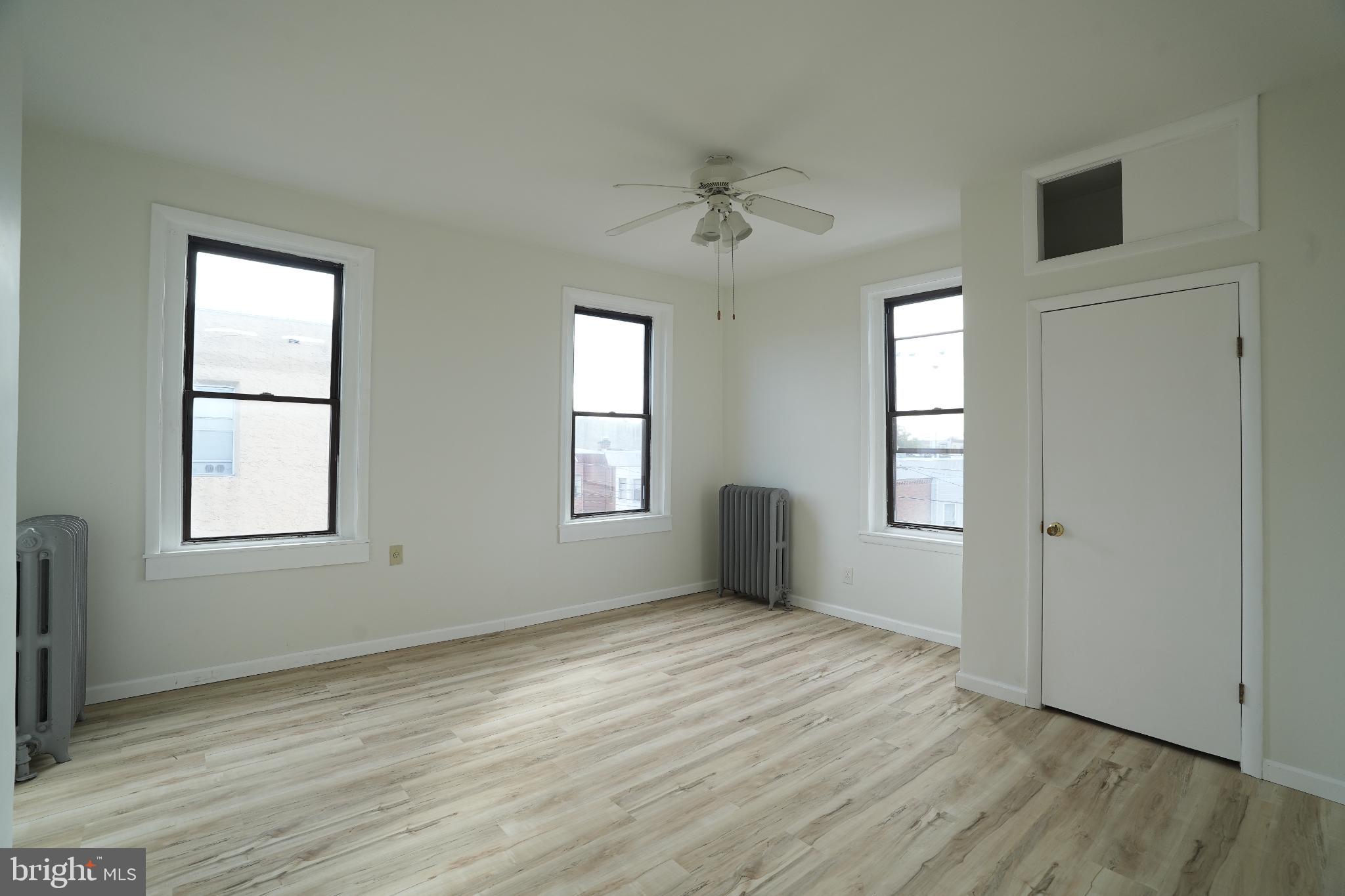 2252 South Hicks Street, Unit 3 Philadelphia, PA 19145 - Photo 5 of 6 a view of an empty room with a window and wooden floor