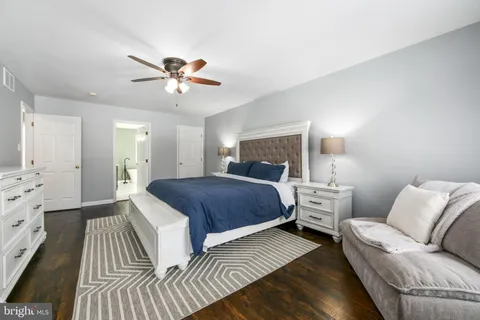 a spacious bedroom with a bed and ceiling fan