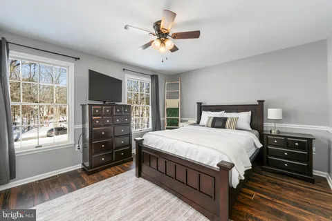 a bedroom with a bed and a flat tv screen on dresser