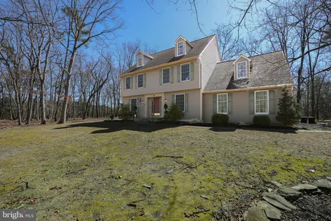 a front view of house with yard and trees around