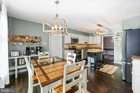a view of a dining room with furniture a kitchen and chandelier