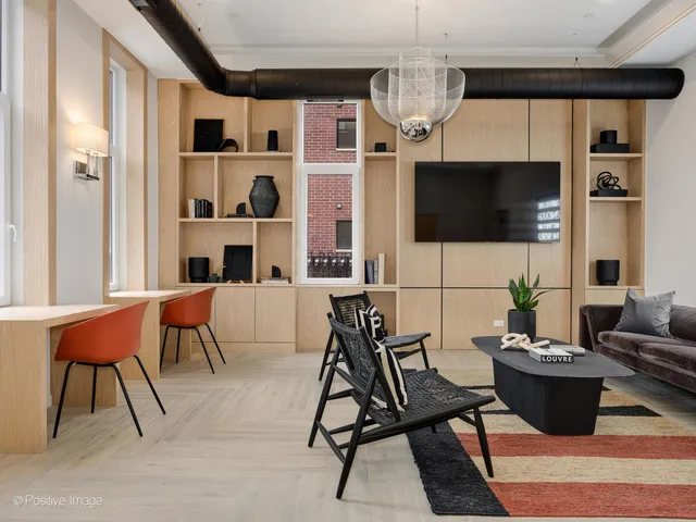 a living room with furniture a flat screen tv and kitchen view