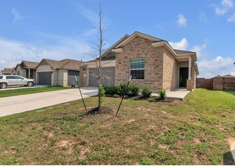 240 Madrid Kyle, TX 78640 - Photo 2 of 25 Ranch-style home featuring brick siding, concrete driveway, and an attached garage