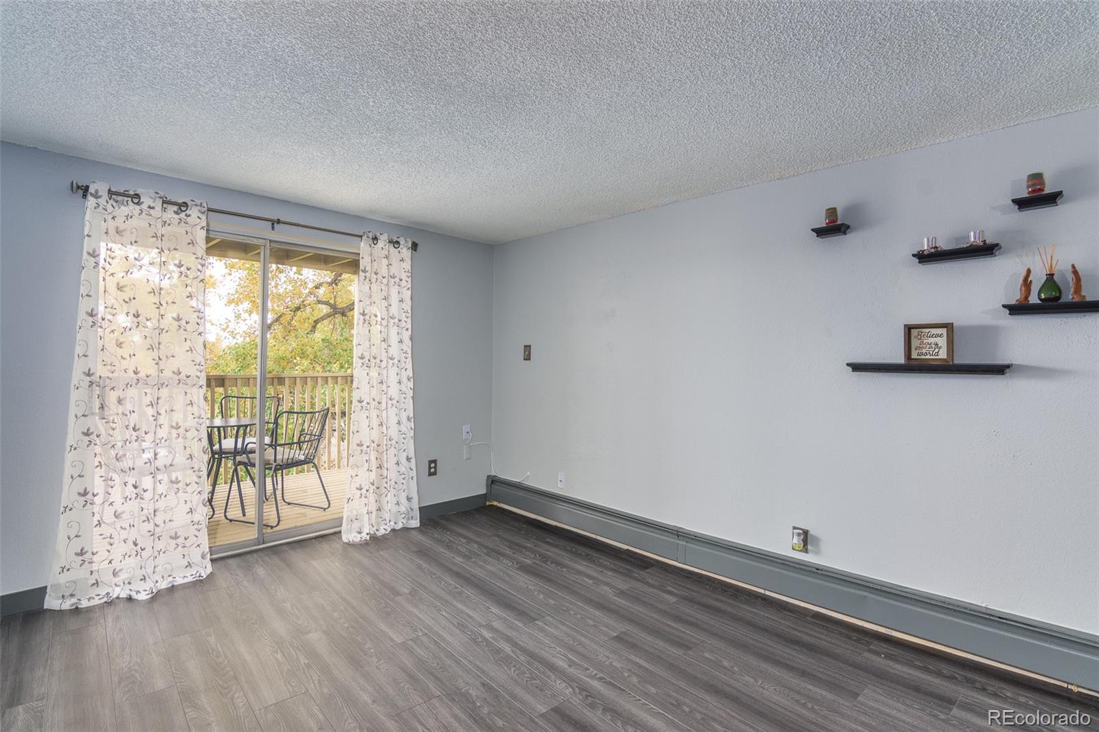 1304 South Parker Road, Unit 347 Denver, CO 80231 - Photo 6 of 27 an empty room with wooden floor and windows